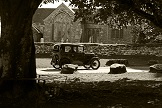 An Austin 7 passes by Widecombe Church
